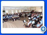 Expansive room of supportive family and friends with the school band at the front right and graduates on the left - 490A7612